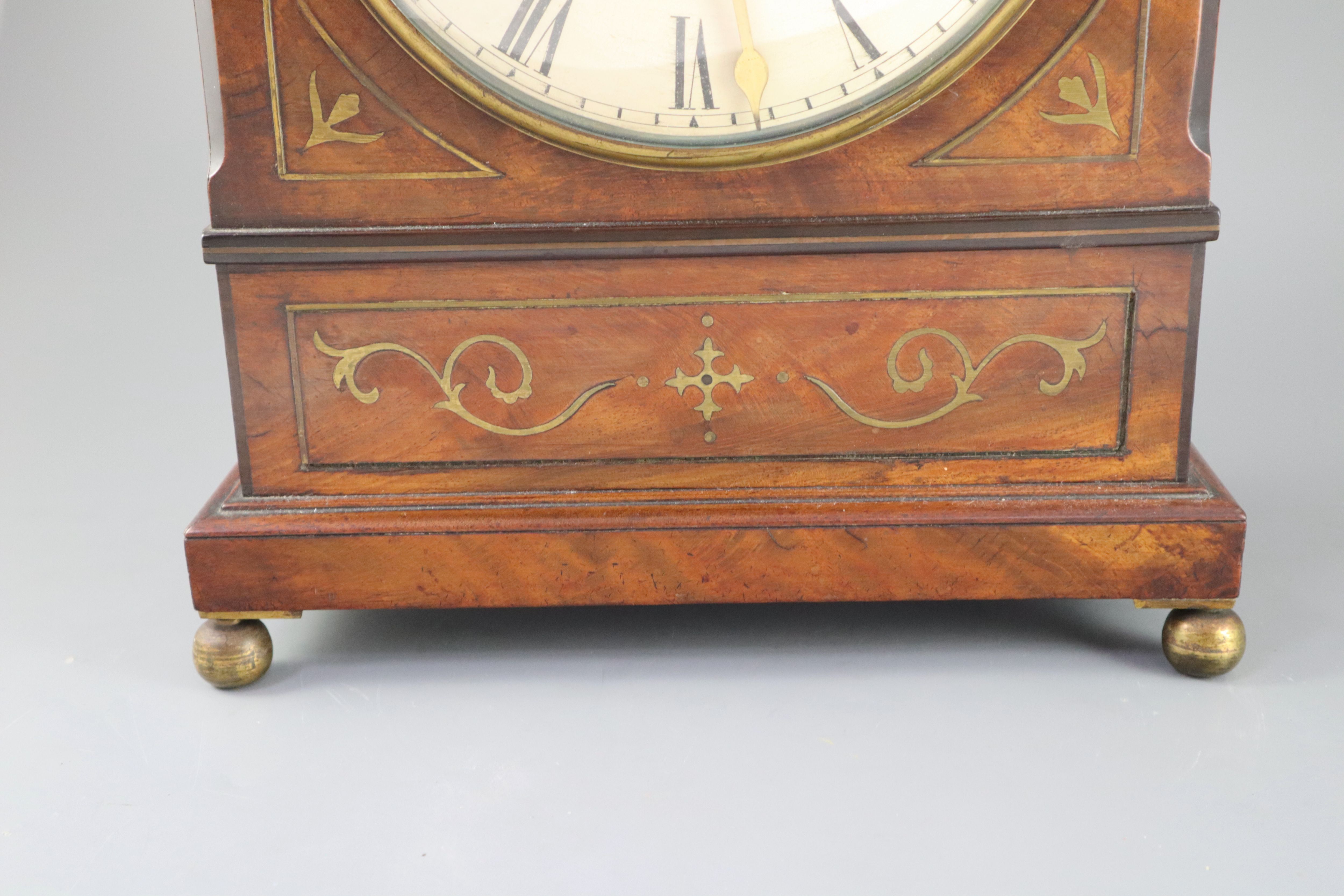 Dwerryhouse & Carter of London. A Regency brass inset mahogany mantel clock, height 19.5in.